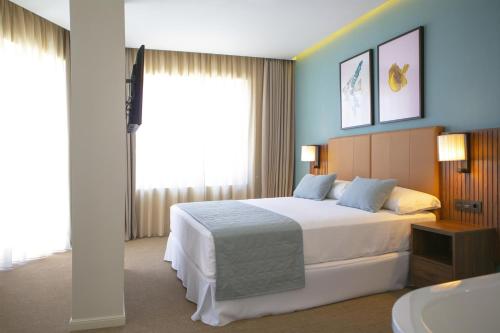 a bedroom with a large bed and a bath tub at Riu Plaza España in Madrid