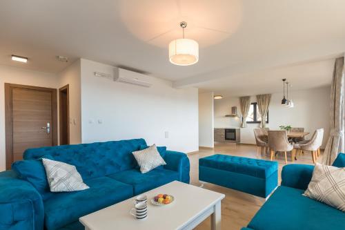 a living room with a blue couch and a table at Apartmani Arapovic in Baška Voda
