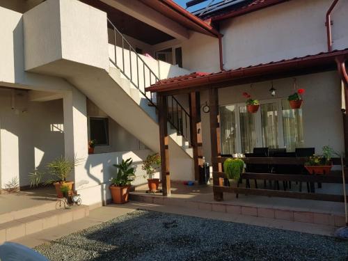 a house with a porch with a bench and potted plants at CASA DRAGON in Sulina