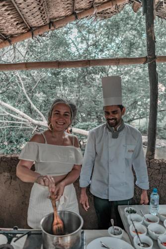 a man and a woman standing in a kitchen preparing food at Arika Villa in Dambulla
