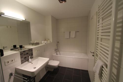 a white bathroom with a sink and a toilet at Park Linné Management GmbH in Cologne