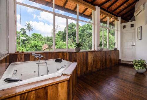 a large bath tub in a room with windows at Viyana Boutique Hotel in Kandy