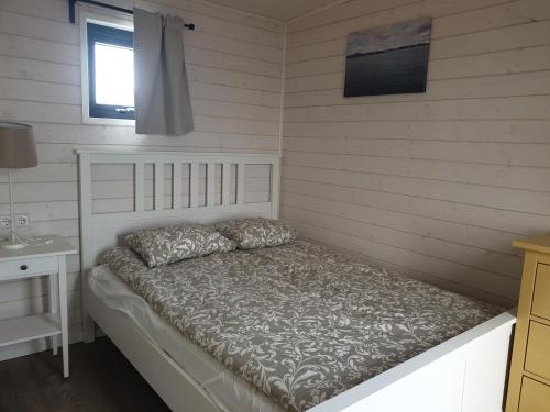 a bedroom with a bed and a table and a window at Black Beach Cottage Small in Ölfus