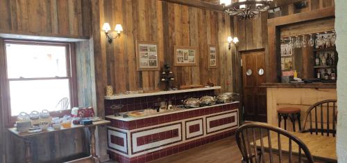 cocina con paredes de madera, mesa y sillas en Rokeby Manor, en Invergarry