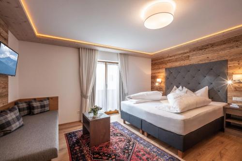a hotel room with a bed and a television at Hotel Viktoria & Landhaus Joggl in Mayrhofen