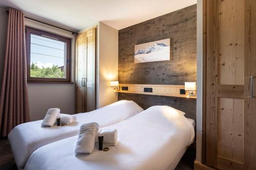 a hotel room with two beds and a window at Résidence Daria-I Nor by les Etincelles in L'Alpe-d'Huez