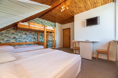 a bedroom with two beds and a flat screen tv at A.V. namai in Palanga