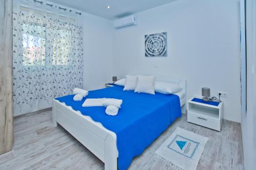 a bedroom with a blue bed with white towels on it at Apartments Magdalena in Hvar