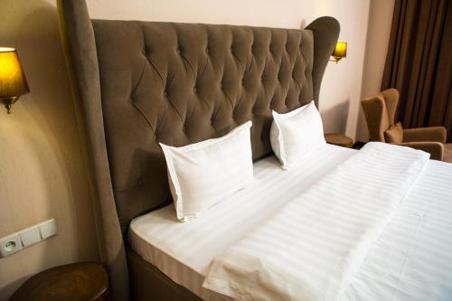 En eller flere senge i et værelse på Keremet Hotel