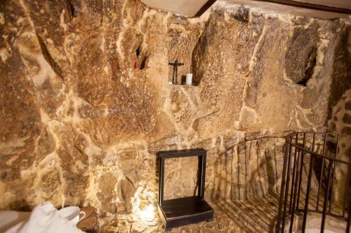 a stone wall with a mirror in a room at Si-Moutique, le Case-grotte degli Avi 2 in Modica