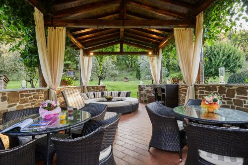 un patio al aire libre con 2 mesas y sillas en Podere la Casina Country Chic, en Rigomagno