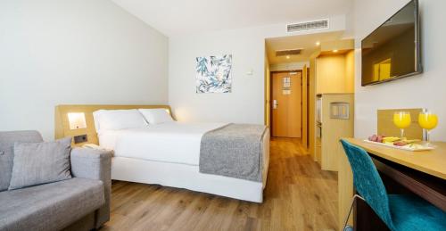 a hotel room with a bed and a couch at Ilunion Valencia 4 in Valencia