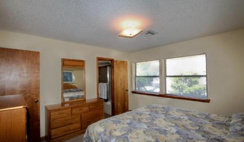 ein Schlafzimmer mit einem Bett, einer Kommode und einem Fenster in der Unterkunft Emerald Isle Resort in Lake Hamilton