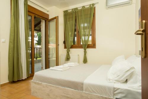 a bedroom with a bed with white sheets and a window at Izabella Sea Side Villa in Siviri