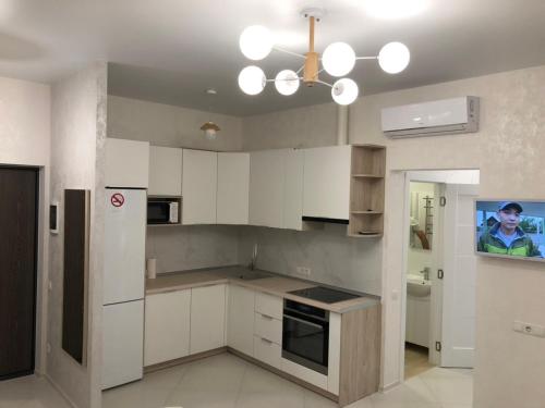 una cocina con armarios blancos y una lámpara de araña en Apartment Gagarinsky in Arcadia en Odesa