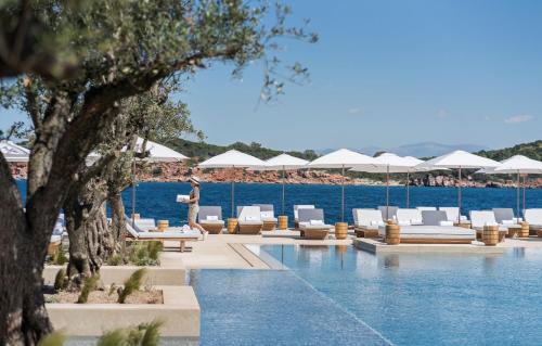 a person standing by the pool at a resort at Four Seasons Astir Palace Hotel Athens in Athens