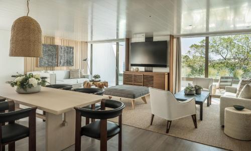 a living room with a table and chairs at Four Seasons Astir Palace Hotel Athens in Athens