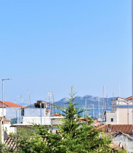 a view of a city with trees in the foreground at Aphrodite Art Hotel Aegina in Egina
