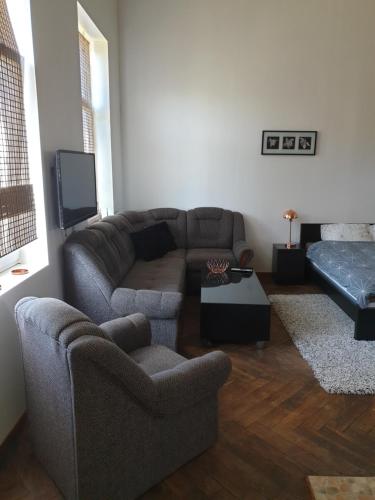 a living room with a couch and a tv at Bartas apartment in Liepāja