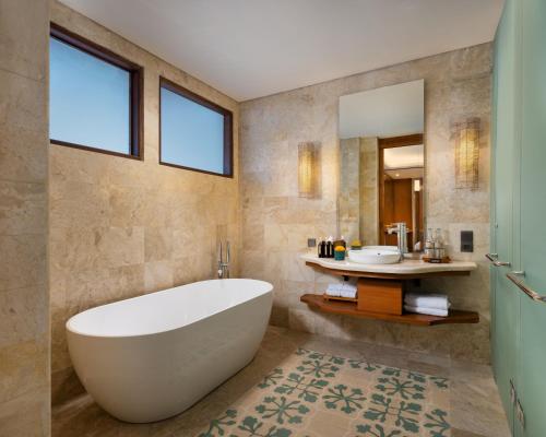 a bathroom with a large tub and a sink at Adiwana Monkey Forest in Ubud