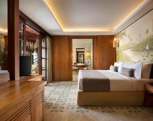 a hotel room with a bed and a television at Adiwana Monkey Forest in Ubud