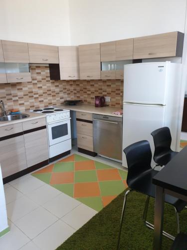 a kitchen with white appliances and a colorful floor at Bartas apartment in Liepāja