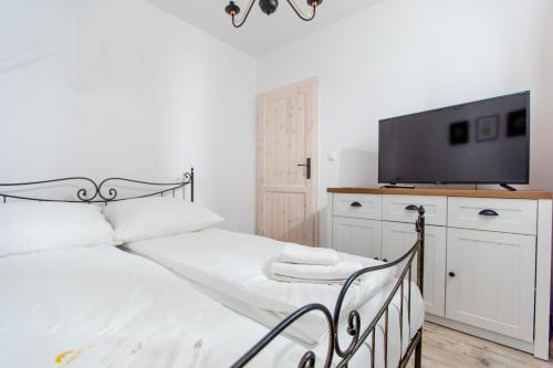 - une chambre avec un lit et une télévision sur une armoire dans l'établissement Apartamenty Sun Seasons 24 - Posesja Bałtycka, à Grzybowo