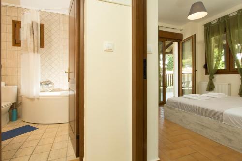 a bedroom with a bed and a tub and a sink at Izabella Sea Side Villa in Siviri