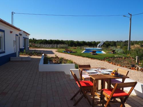 a patio with a table and chairs and a pool at Quinta do Maranhão in Lagos