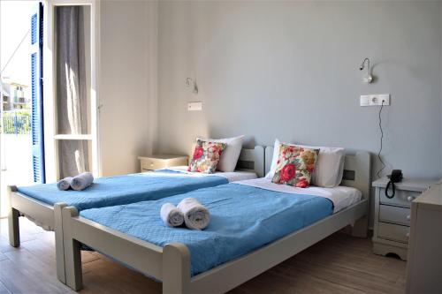 a bedroom with two beds with towels on them at Aphrodite Art Hotel Aegina in Egina