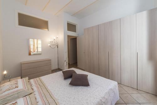 Finalborgo - Casa Nanetti 6 posti in centro في فينالي ليغوري: غرفة نوم مع سرير أبيض كبير وخزانة