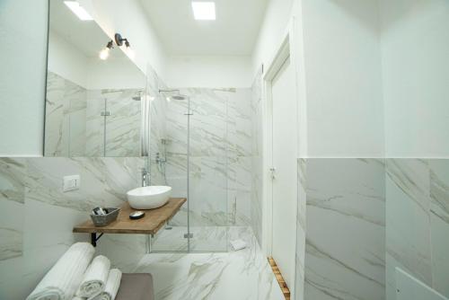 a white bathroom with a sink and a mirror at Piccolo Feudo in Sanluri