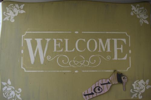 a sign that says welcome with a bottle of champagne at Aphrodite Art Hotel Aegina in Egina