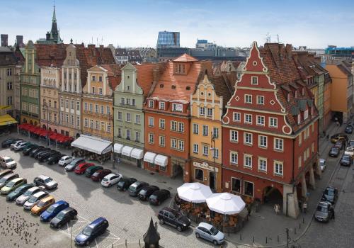 a city with buildings and cars parked in a parking lot at Solny Square Aparthotel in Wrocław