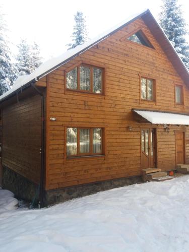 a log cabin in the snow with snow at Ялинка in Migovo