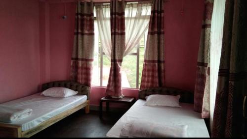 two beds in a room with a window at Rainbow Valley Resort in Sonāda