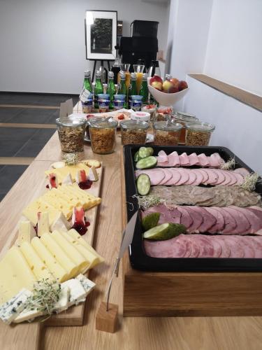 einen Tisch mit Fleisch, Käse und anderen Lebensmitteln in der Unterkunft Brassel Aparthotel in Breslau
