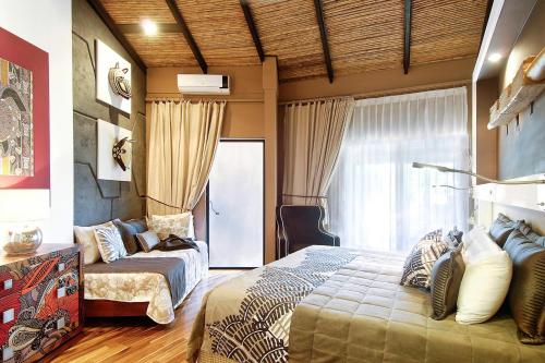 a bedroom with a bed and a couch at Villa Don Vito in Tamarindo