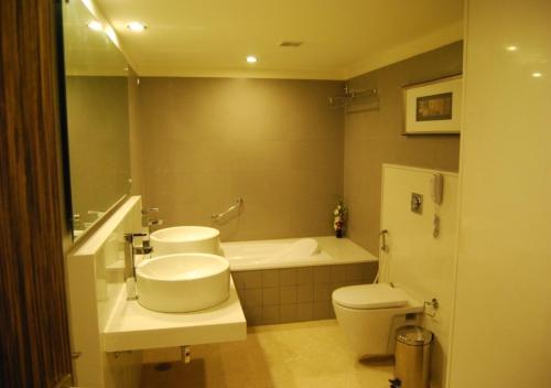 a bathroom with a sink and a tub and a toilet at Hotel Royal Park Kakinada in Kākināda