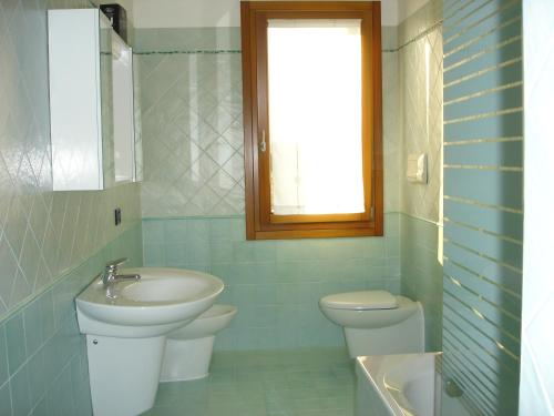 a bathroom with a sink and a toilet and a window at La Casa di Linda in Mirano