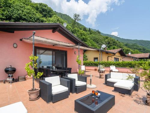 a patio with couches and a table with a grill at Belvilla by OYO Panoramica in Oggebbio