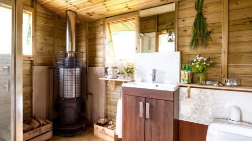 a bathroom with a sink and a stove in a trailer at Brocklands Farm Glamping in Petersfield