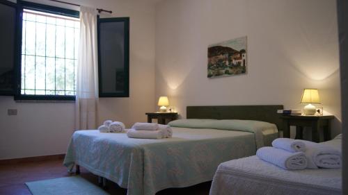 1 dormitorio con 2 camas y toallas. en Le Sughere, en Padru