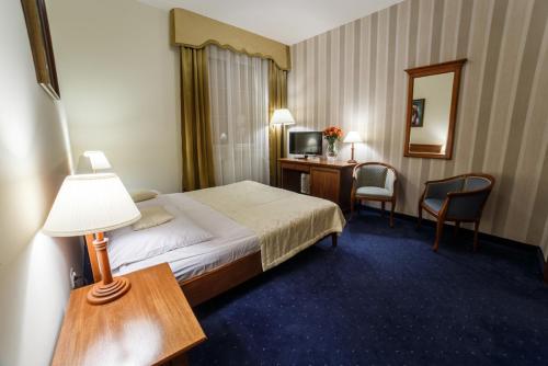 a hotel room with a bed and a desk at Hotel Wellness & Spa Nowy Dwór in Rzeszów