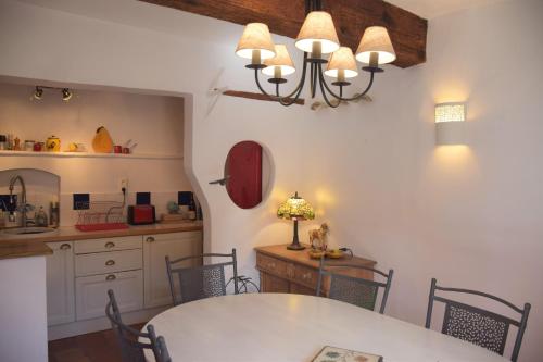 une cuisine et une salle à manger avec une table et des chaises dans l'établissement La Demeure de Sophie, à Vinsobres