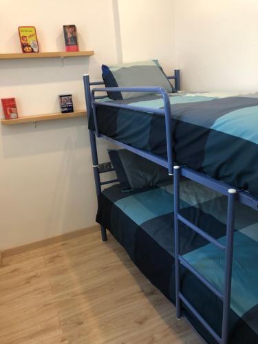ein Schlafzimmer mit einem Etagenbett mit einer blauen Tagesdecke in der Unterkunft ÀTIC Mercat Central in Tarragona