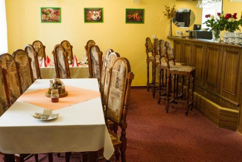 a dining room with a white table and chairs at Penzion Pomnenka in Luhačovice