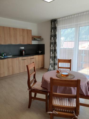 una sala da pranzo con tavolo e sedie e una cucina di Amalia Haus a Tux