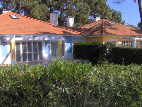 a house with an orange roof and bushes at Aldeamento Turistico Casas da Comporta in Comporta