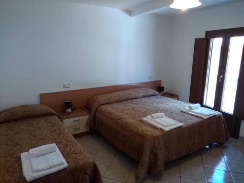 a hotel room with two beds and a window at Il Narciso appartamenti in Assergi